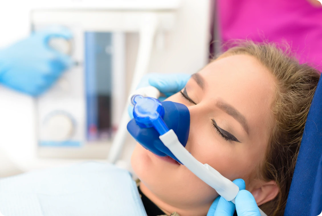 Patient receiving dental sedation with nasal mask.